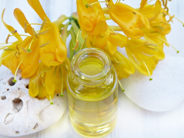jojoba oil bottle next to flower.