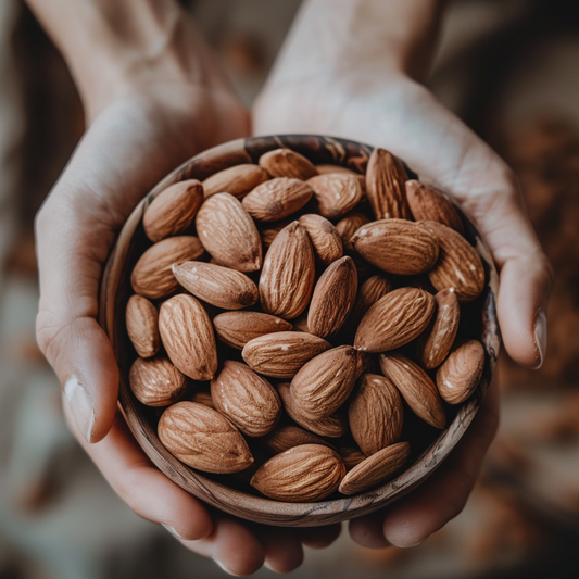 a person holding a bowl of almonds in their hands.