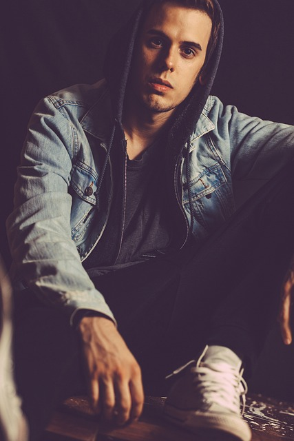 a man wearing a hoodie and sneakers.
