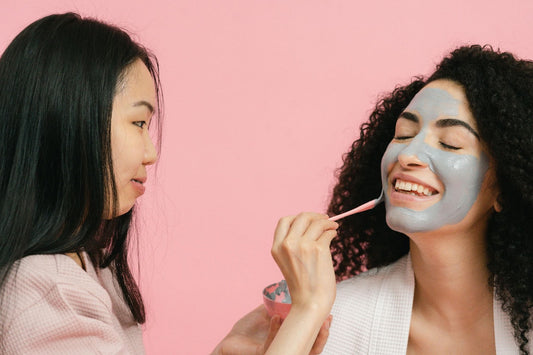 Two females, one applying clean natural skin care on her friend.