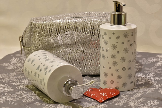 glamorous bottles of skincare products next to silver purse on a table.